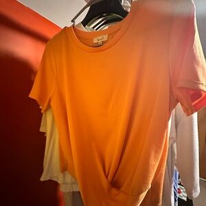 Orange. Fits like a small/medium. Second picture is more of an accurate color.